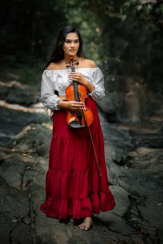 Woman holding a violin in a natural outdoor setting